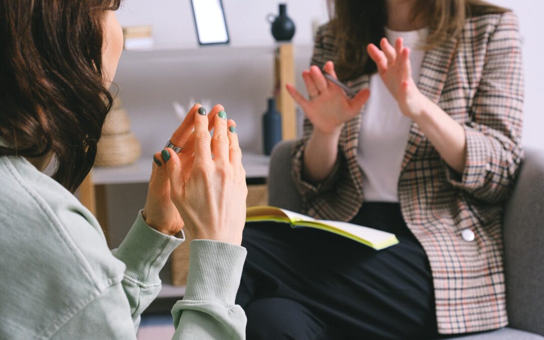 Crop unrecognizable female psychologist and patient discussing mental problems during session